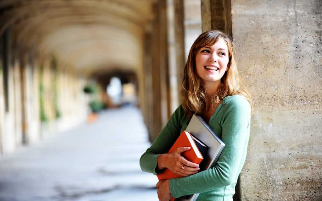 Female smiling holding books