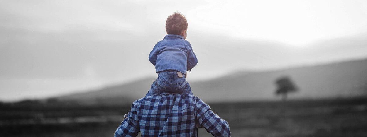 Image of father with son on shoulders