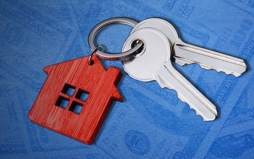 keyring with 2 keys and a house keychain laying over a blue background with dollar bill images overlaid