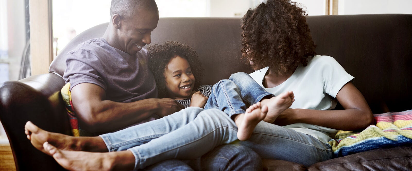 A young military family sitting on a couch together.