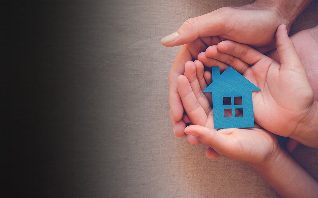 Photo of hands holding a house to represent estate planning for children and minors.