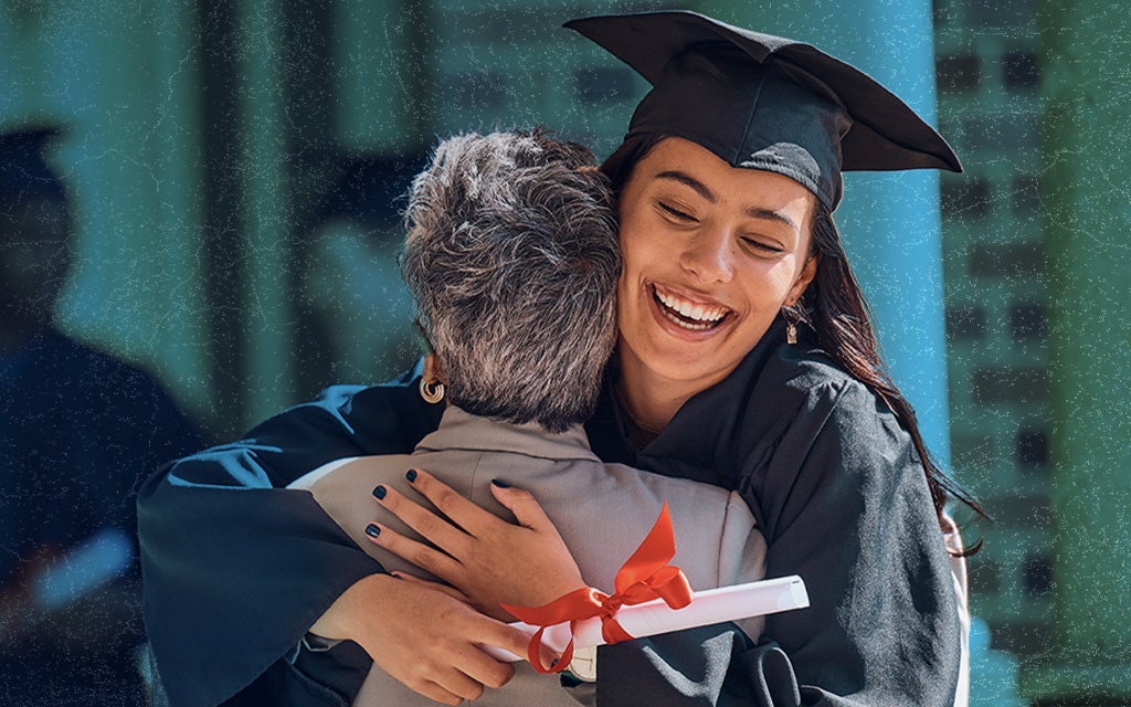 graduate in cap and gown hugging an elderly family member