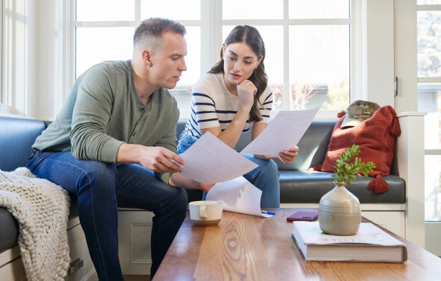 An off-duty military couple review financial documents together at home.