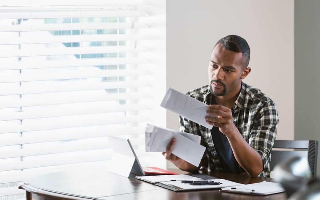 Man sitting at a desk looking through mail