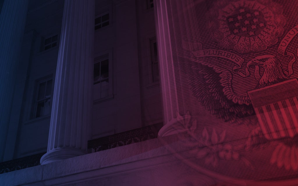 Close-up of a government building façade with columns, blended with a U.S. flag and eagle seal in red and blue lighting.
