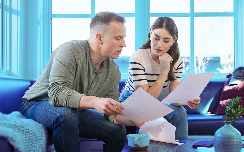 Two people seated indoors reviewing paperwork.