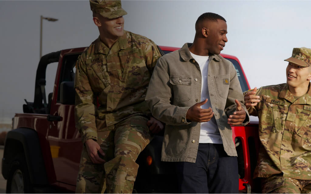 Three men in military uniforms engaged in conversation.