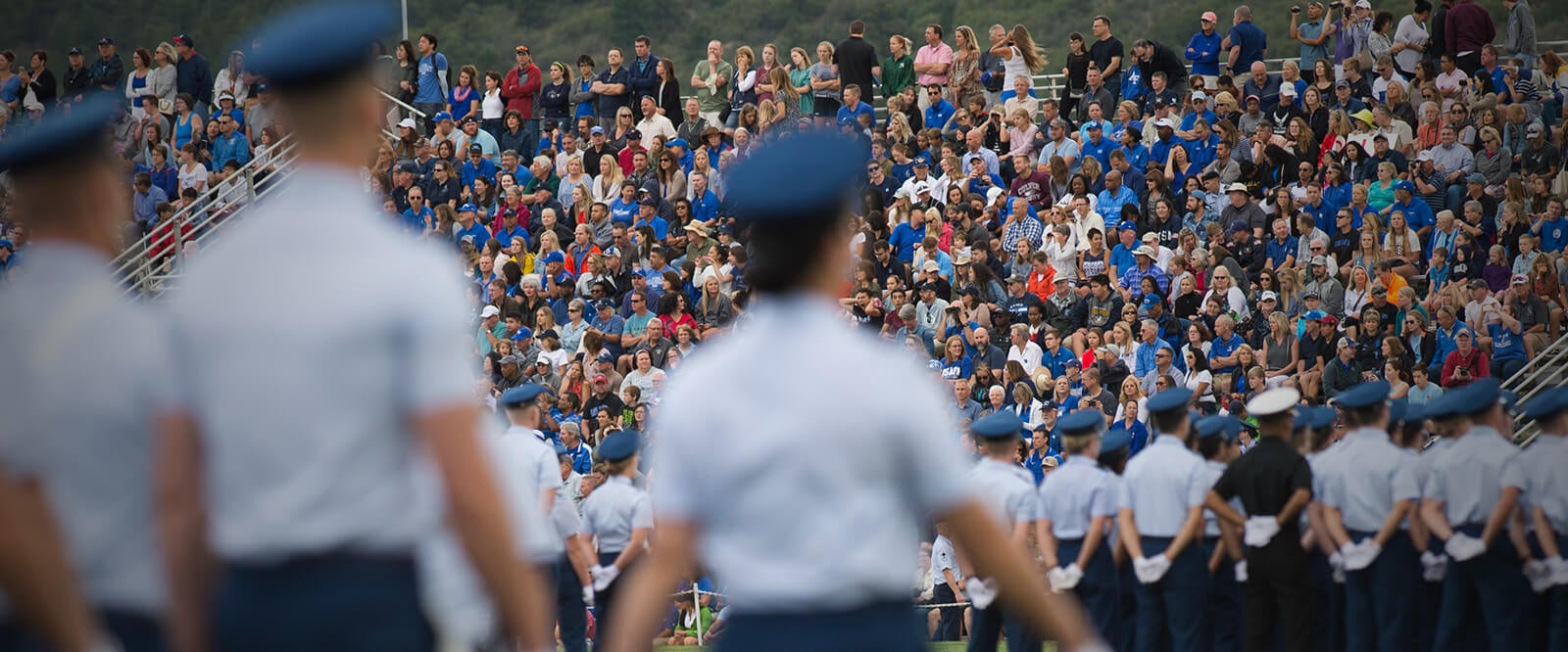 A group of students parading in front of a crowd during a Military Academy Parents Weekend.