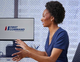 financial advisor consulting with a couple at a desk with a first command logo on the monitor in the background