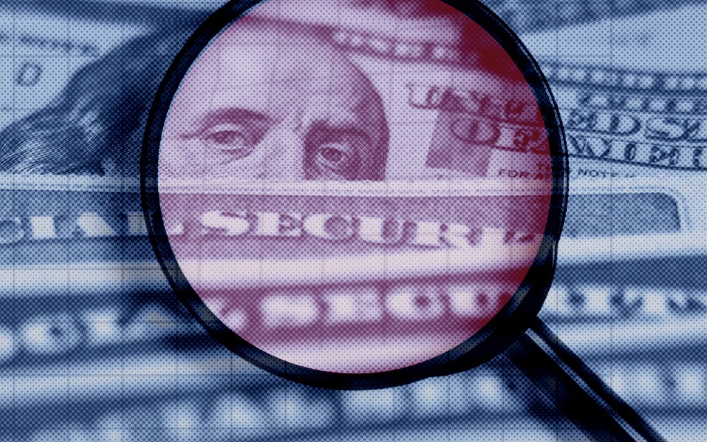 magnifying glass on US dollar bill and social security cards