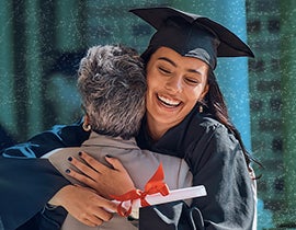 graduate in cap and gown hugging an elderly family member