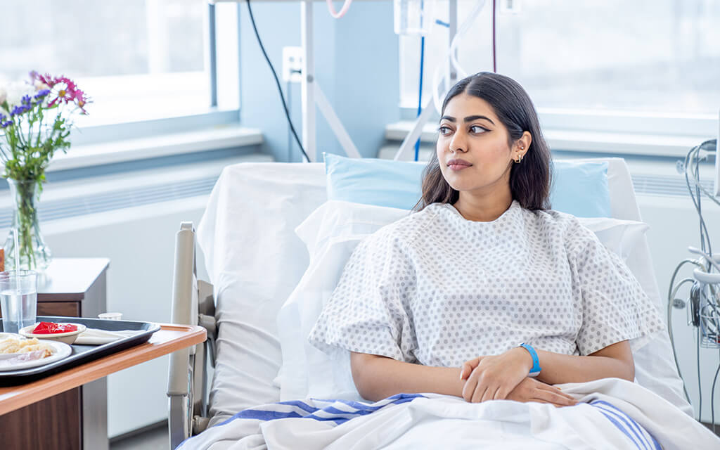 Woman laying in hospital bed.