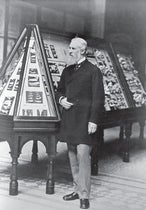 William Henry Flower standing in front of one of his exhibition cases, Natural History Museum, photograph, undated, ca 1896 (nhm.ac.uk)