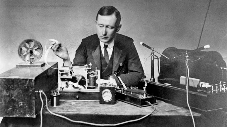 Marconi with a slightly different transmitter (right) and receiver, with paper-tape recorder (left), photograph, late 1890s (bbc.com)