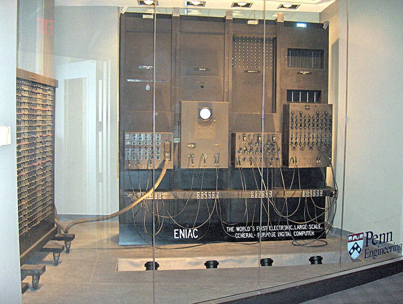 ENIAC display at the Moore School, University of Pennsylvania, with an original ENIAC function table at left and four original banks of accumulators and integrators, recent photograph (Wikimedia commons)