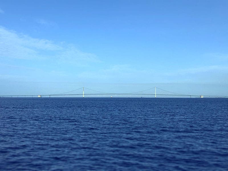 Long view of the Mackinac Bridge, showing that the “hump” often seen in photographs is a telephoto foreshortening illusion (Wikimedia commons)