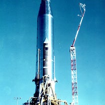 Atlas 10B rocket on the launch pad at Cape Canaveral, with the SCORE tape recorders and radios under the fairings at top, photograph, December 1958 (Wikimedia commons)