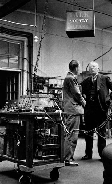 Ernest Rutherford (with cigar) under a lit-up “Talk Softly Please” sign at the Cavendish Lab, 1934, photograph by Walter Andrews, Cambridge University Digital Library (cudl.lib.cam.ac.uk)