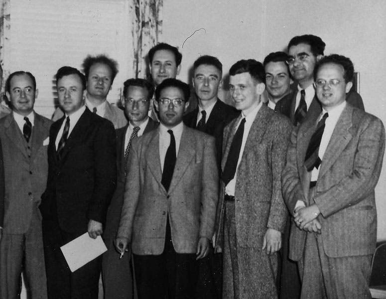 Detail of group photo of Shelter Island Conference, 1947.  Robert Serber is the short man in the second row, just left of center, in front of the drapes; Hans Bethe, with the frizzy hair, is just to the left of Serber, in the rear; Robert Oppenheimer is the fifth from the right, in the second row; Richard Feynman is third from the right, in the rear, Institute for Advanced Study archives (albert.ias.edu)