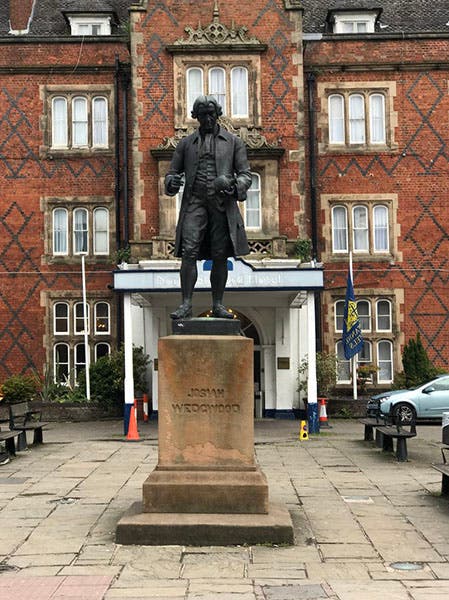 A bronze statue of Josiah Wedgwood, sculpted by Edward Davies and put in place facing the train station in Stoke-upon-Trent in 1862; what is now the North Stafford Hotel is in the background (photo by Jonathan Hutchins on geography.org.uk)