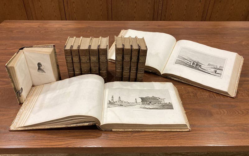 All 12 volumes of Histoire scientifique et militaire de l'expédition française en Egypte, by Louis Reybaud, 1830-36, including 10 octavo text vols, and two oblong quarto atlases; the opened text volume at left shows the portrait of André Detertre, who did all of the 160 portraits in the 10 volumes (Linda Hall Library copy)