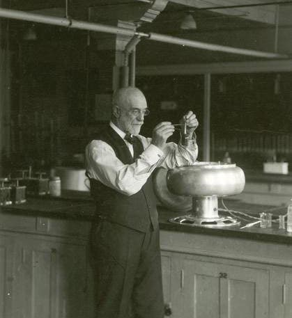 An older Stephen Babcock in his lab, standing by a centrifuge and demonstrating the butterfat milk test, undated photograph (wisconsinhistory.org)