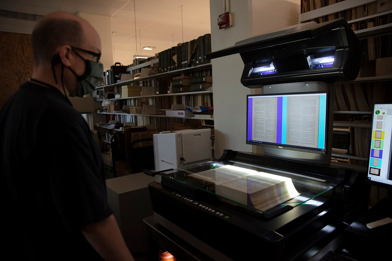 Linda Hall Library digital initiative technician scanning book.