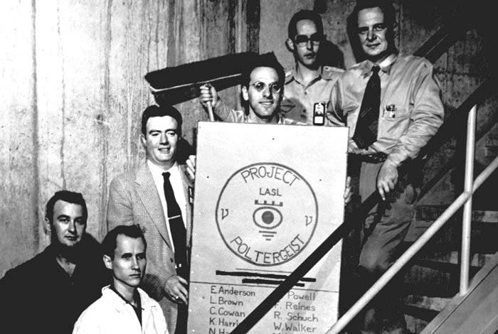 Group portrait of the “Project Poltergeist” team searching for the neutrino; Frederick Reines holds the poster, Clyde Cowan is at far right; photograph, ca 1953, Los Alamos National Laboratory (lanl.gov)
