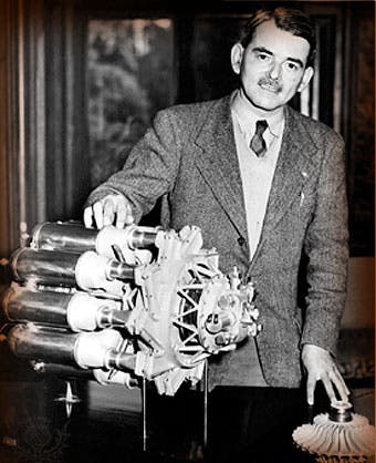 Frank Whittle with a model of his W.1 turbojet engine; a model of the impeller for the centrifugal compressor also sits on the table (asme.org)