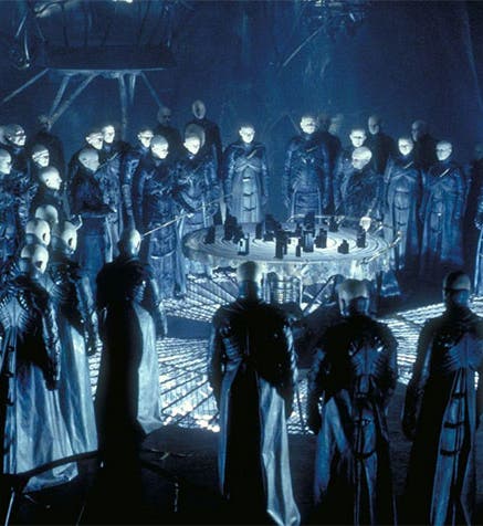 The “Strangers” in the underworld, standing around a model of the City above, a movie still from Dark City (1998), Internet Movie Database (imdb.com)