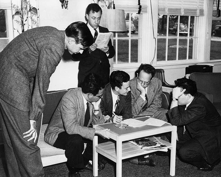Renormalization in progress at the Shelter Island Conference, 1947; Feynman, in the center on the couch, draws diagrams for Schwinger, at right on the floor, while another prodigy, John Wheeler, does his own thing at the back; Willis Lamb, whose discovery of the Lamb shift was a major topic of discussion at Shelter Island, stands at left; photograph property of the Julian Schwinger Foundation (schwingerfoundation.org)