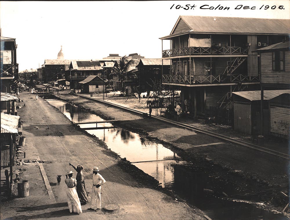 Tenth Street, Colón, before paving.
Before the mosquito theory was accepted, filth and odors from decaying waste and garbage were assumed to be the cause of diseases, including yellow fever. As part of a massive cleanup campaign, the U.S. moved quickly to drain standing water, eliminate open sewers, and pave streets. Sewers were installed in Colón in 1906. (Note the manhole cover in the foreground.)  