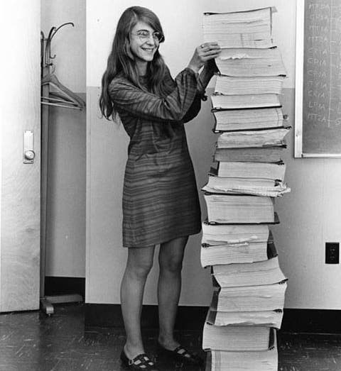 Margaret Hamilton standing next to books of code for the Apollo Guidance computer, MIT Instrumentation Lab, 1969 (nasa.gov)