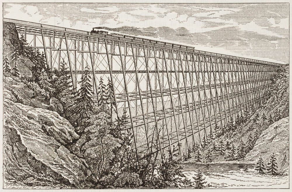 A train crossing a trestled viaduct.