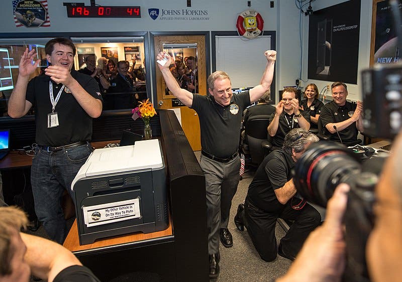 Some of the New Horizons team, with lead investigator Alan Stern at center, celebrating the successful fly-by, July 14, 2015 (Wikimedia commons)
