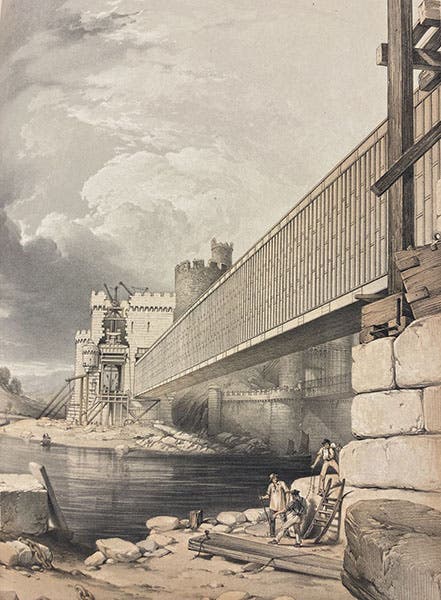View of the first tube of the Conwy Tubular Bridge in place, while a hydraulic jack stands ready to hoist the second tube (out of the field of view) into position, detail of tinted lithograph in The Britannia and Conway Tubular Bridges, by Edwin Clark, published with the sanction and under the supervision of Robert Stephenson, Atlas, plate 36, 1850 (Linda Hall Library)