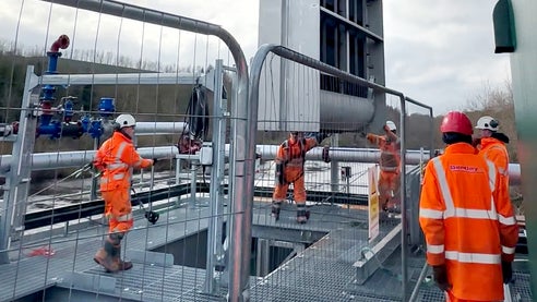 Workers in orange safety gear install Hydrolox screening equipment at the Northumbrian Water River Tyne site.