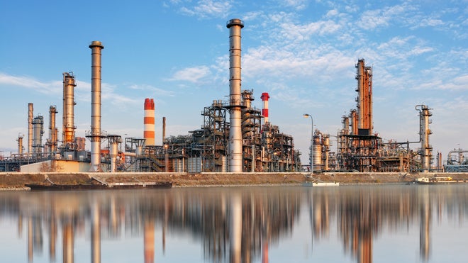 Refinery towers with reflections on water