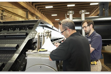 Two men examining paperwork next to Hydrolox water screen