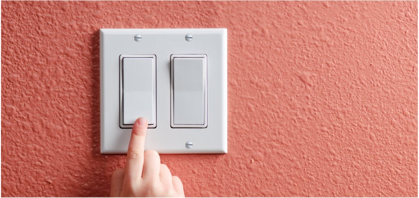 Light switch being turned off or on with a human hand.