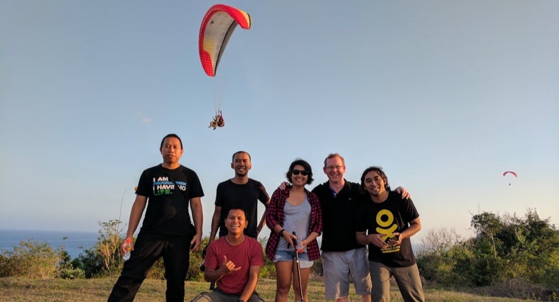 Team members paragliding in Bali