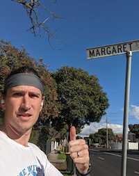 Andy standing in front of a street sign