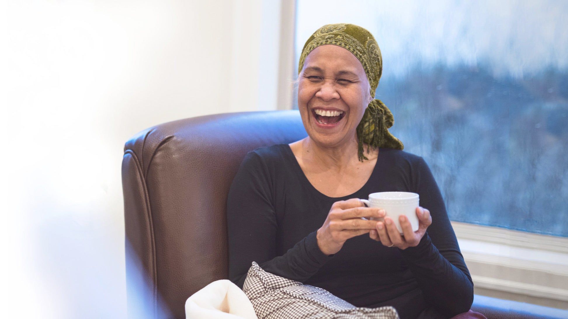 Lady with cup of tea laughing