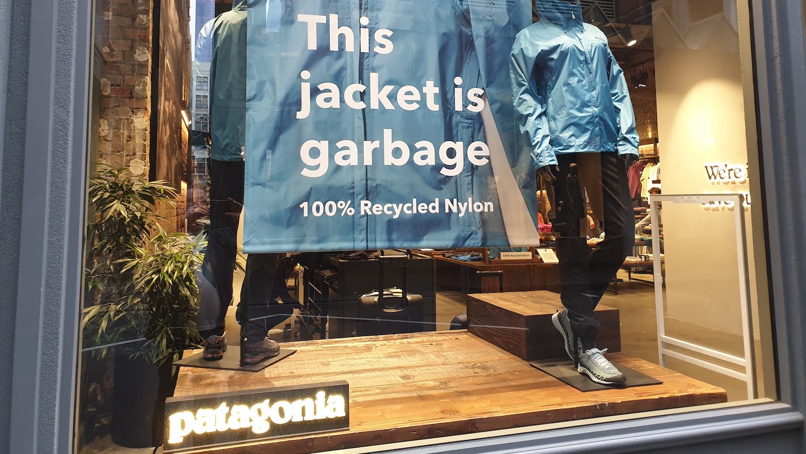 Picture of a Patagonia store-front with a message that reads 'This jacket is garbage'.