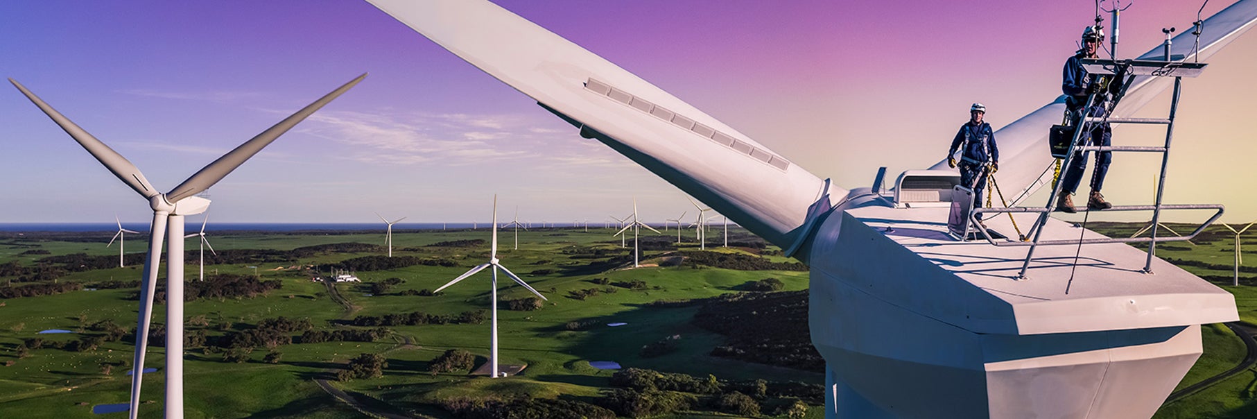 Two men standing on a renewable energy generator