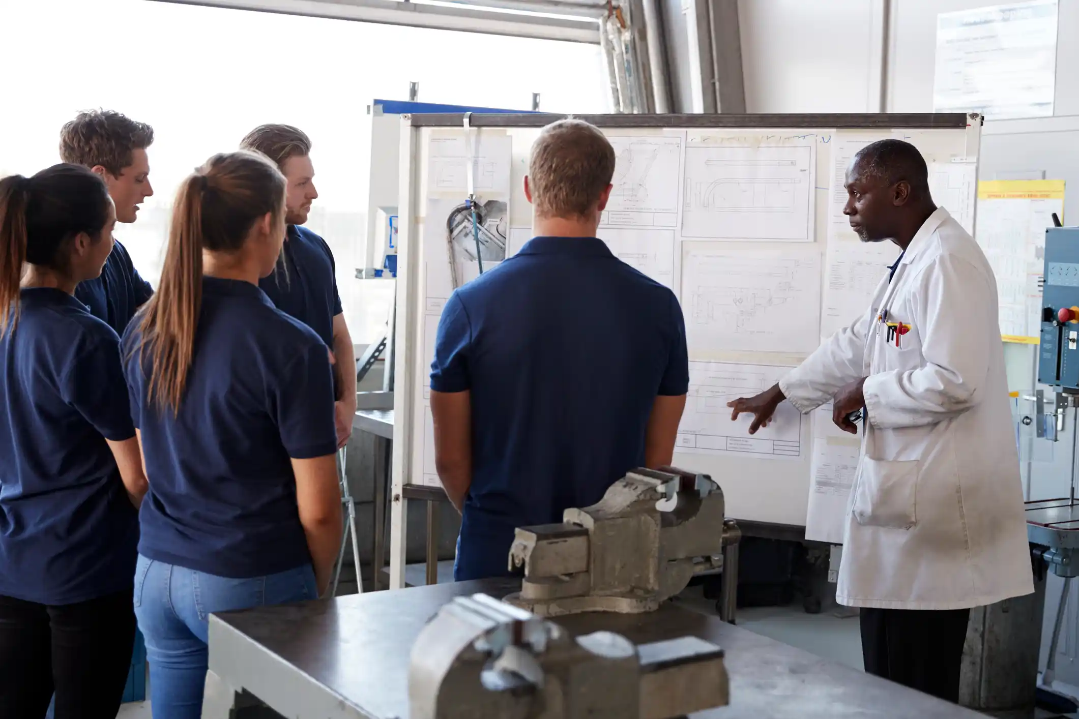 Engineering students looking at a notes on a board