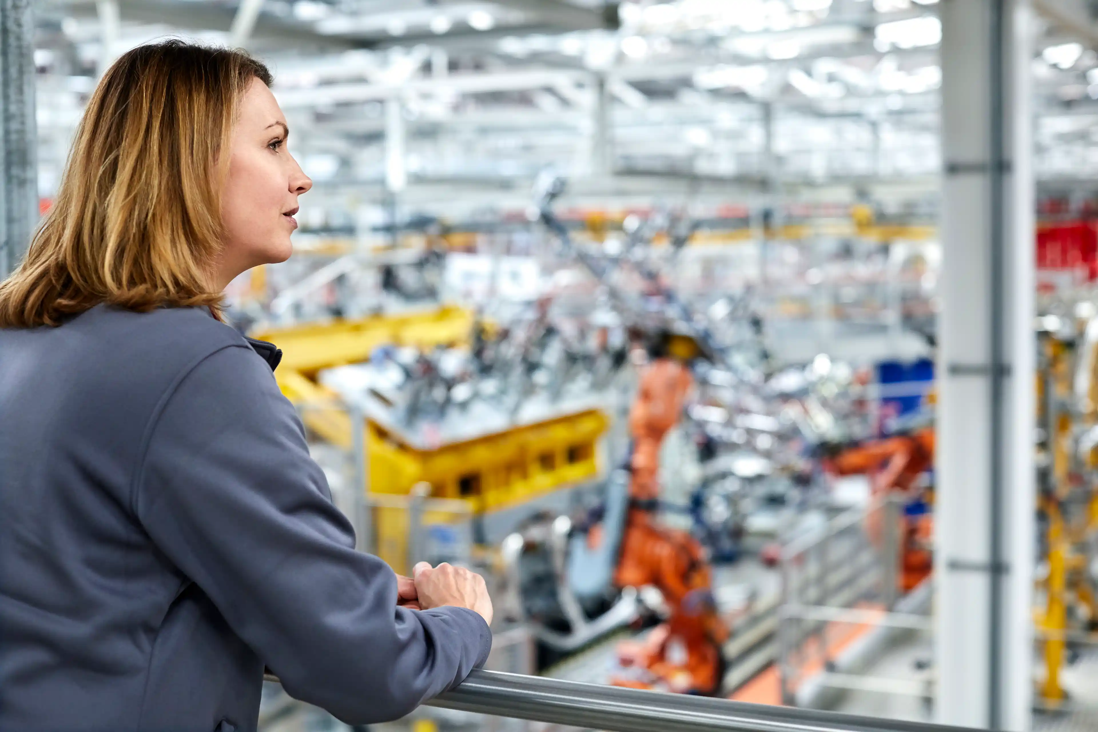 Worker overseeing workforce in manufacturing warehouse 