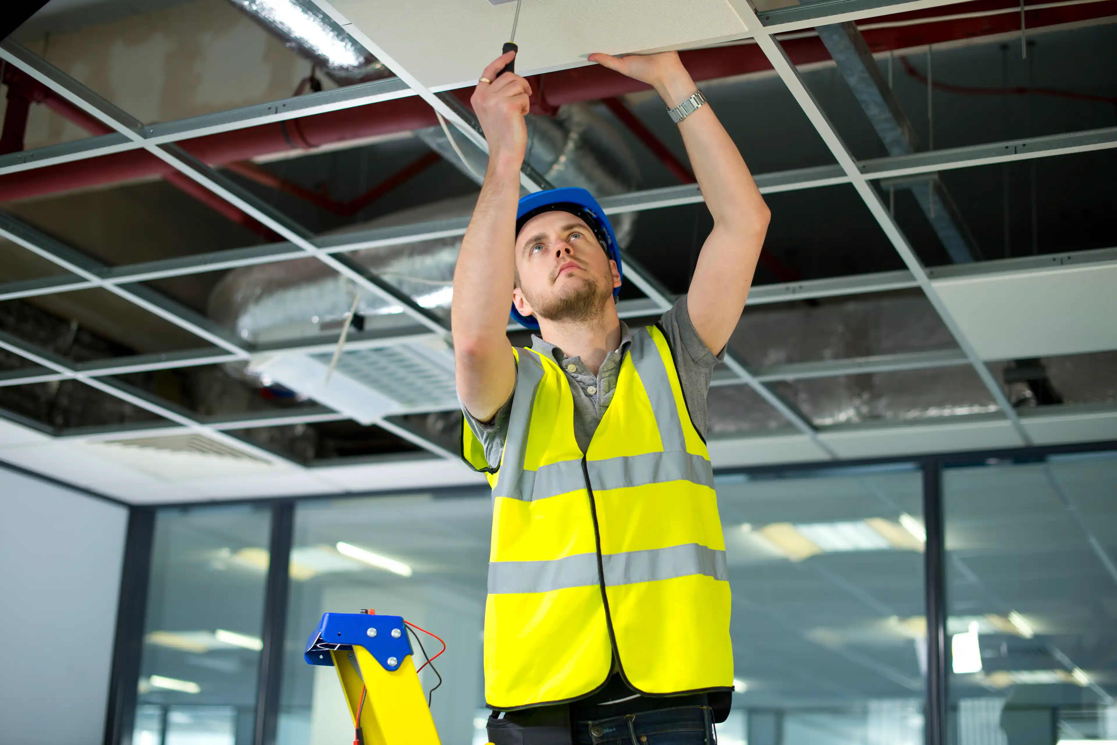 Engineering student replacing wiring in ceiling 