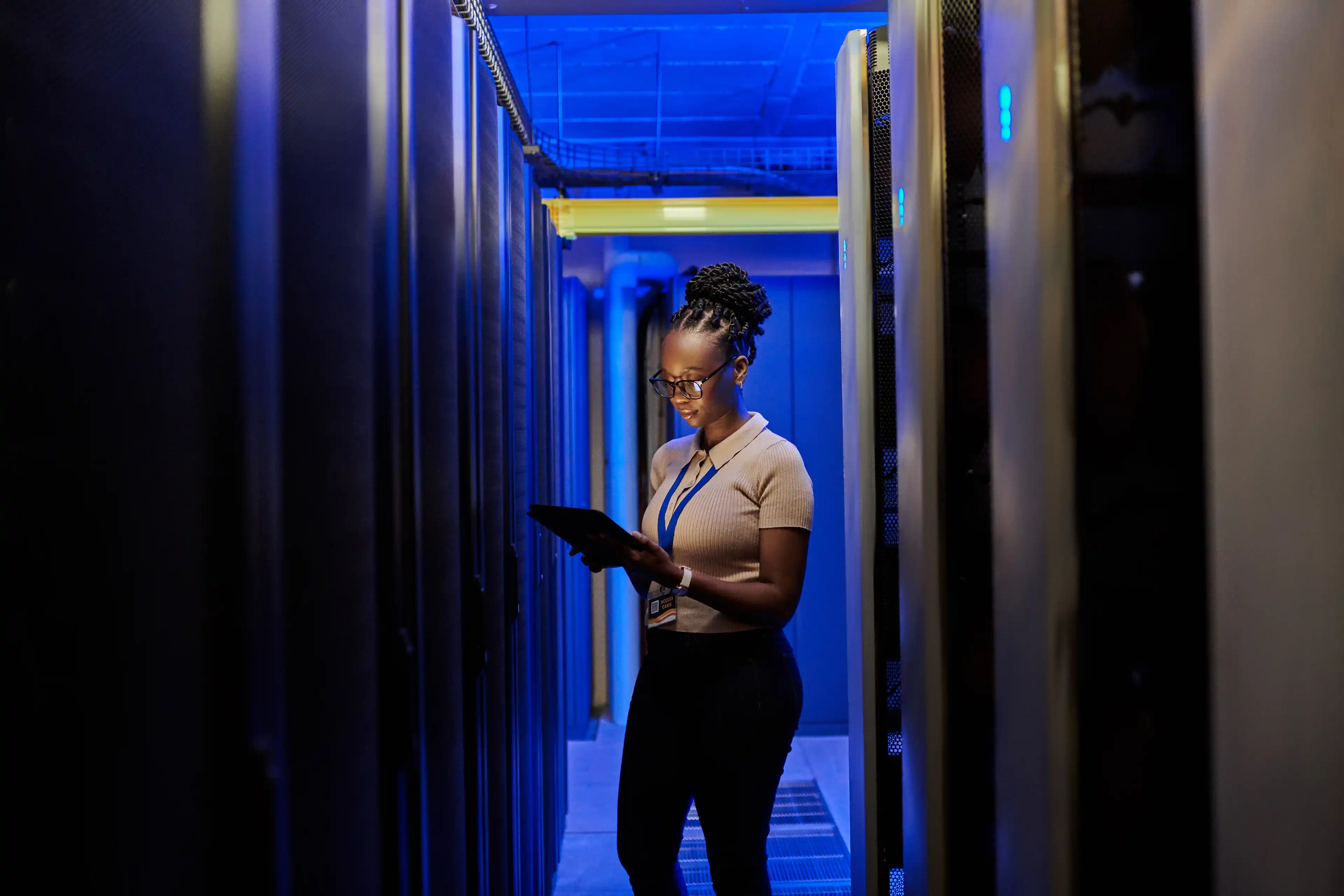 Engineer working on tablet in blue light room