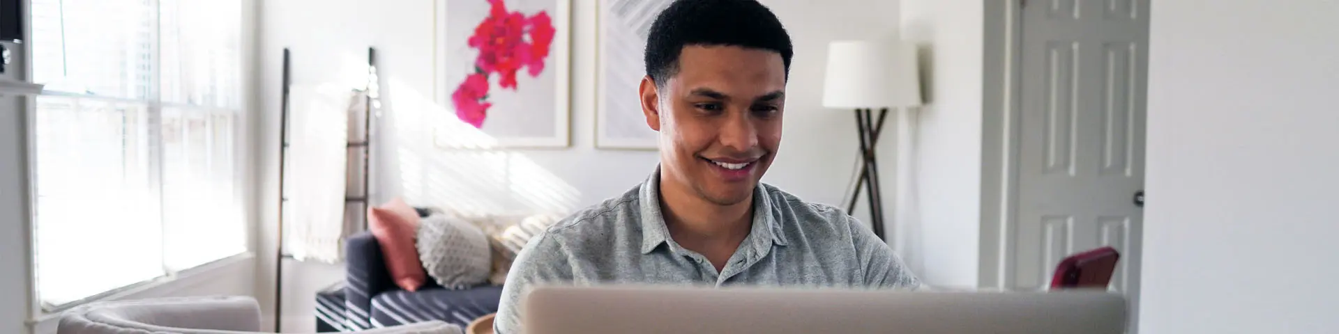 Image of man smiling in front of laptop